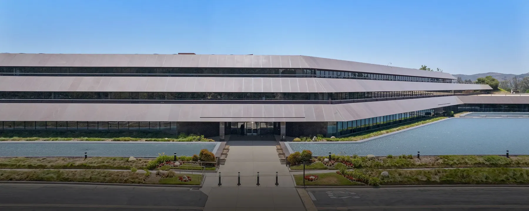 One Westlake, a terraced three-story office building fronted by reflecting pools